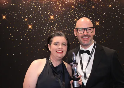Two guests holding an award trophy at a corporate evening event