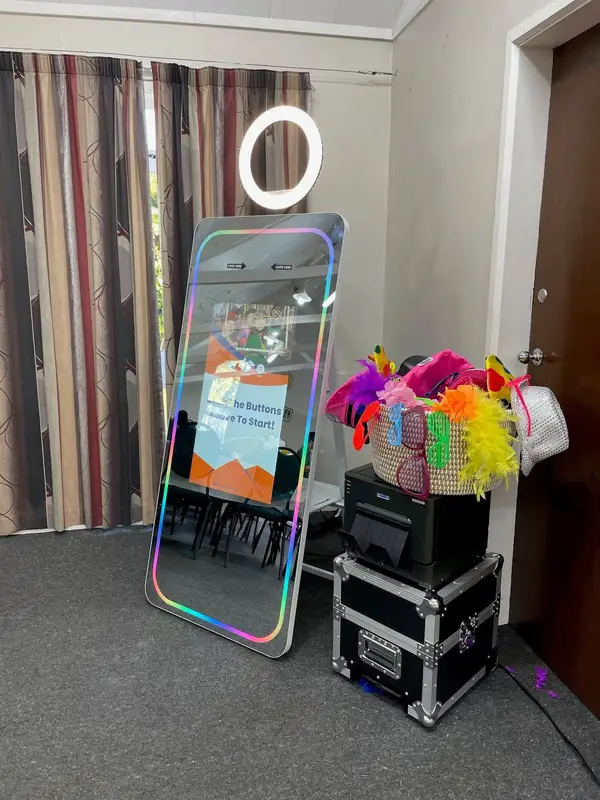 Large Mirror with a ring light and illuminated frame beside a printer and colourful props