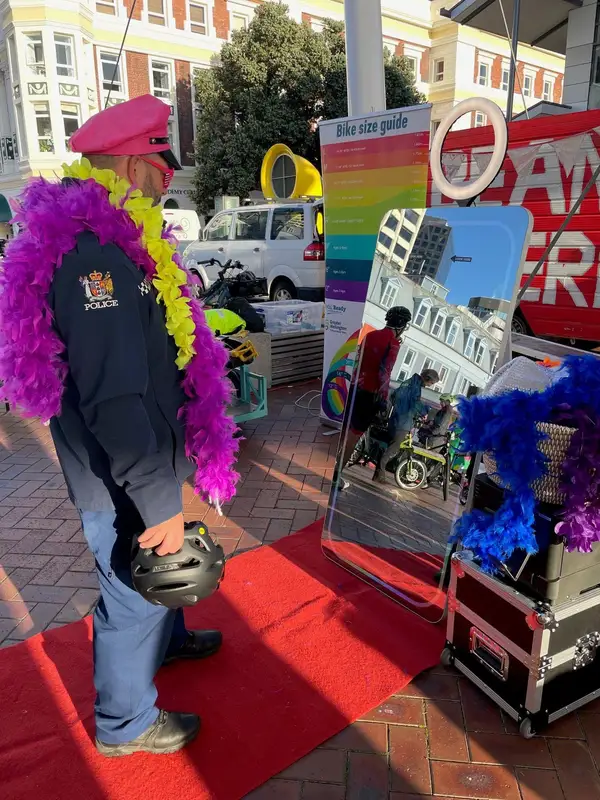 Large Mirror booth beside a printer and feather boas at an outdoor event